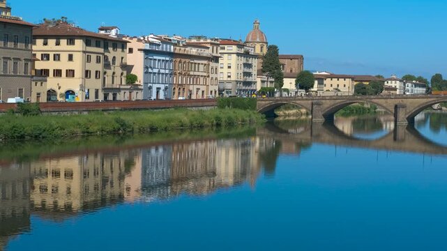 Florence cityscape reflecting on arno river with ponte santa trinita. Colorful buildings along arno river in florence, italy, are reflecting on the water surface under ponte santa trinita bridge