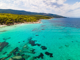 Obraz premium Mediterranean sea. Incredible blue water on Kavourotrypes or Orange Beach in Sithonia, Halkidiki, Greece. Aerial panoramic drone view from above, top view from drone.