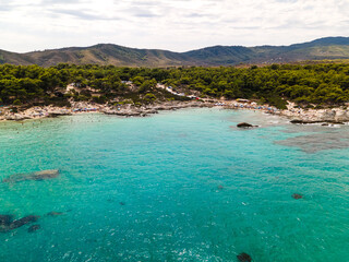 Obraz premium People relaxing on Kavourotrypes or Orange Beach in Sithonia, Halkidiki, Greece. Incredible beach with clear blue water. Aerial panoramic drone view from above, top view from drone.