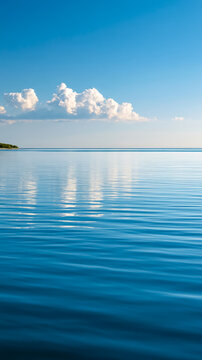 Serene blue lake with calm ripples and fluffy clouds in clear sky