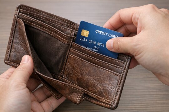 A person holding a credit card in their wallet, a common everyday scene