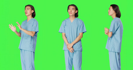 Obraz premium Male nurse nodding on camera and saying yes, showing approval and agreement gesture over green screen backdrop, with pleased medical assistant doing good symbol, agreeing with something.