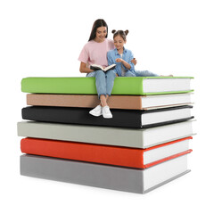 Naklejka premium Mother and daughter reading while sitting on stack of books against white background
