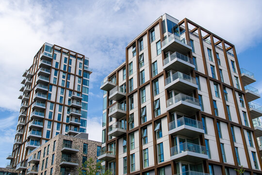 Modern residential apartment buildings with balconies under blue sky in urban setting