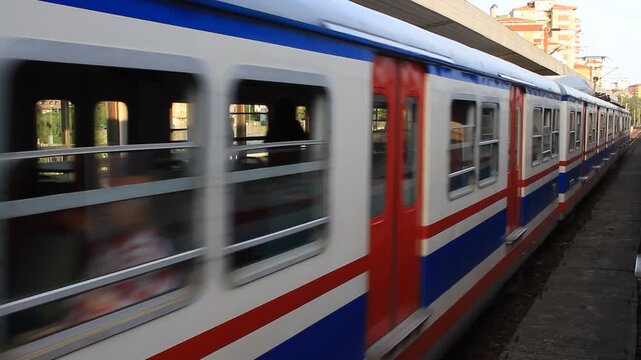 Archival footage of the classic old commuter train operating on the Haydarpaşa-Gebze line, moving past a station platform in Istanbul, Turkey.