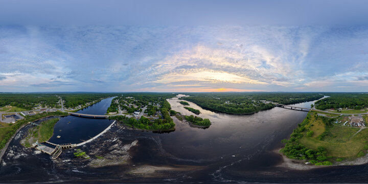 Aerial 360 in Howland, Maine of River Confluence With Bridge, Dam and Islands at Sunrise Over Lush Countryside