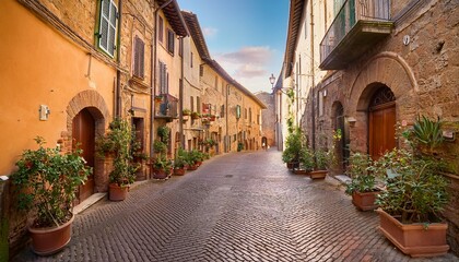 Fototapeta premium quaint street lined with plants outside historic buildings in the medieval old town of orvieto umbria italy
