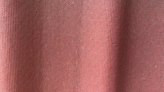 Closeup red corrugated roof texture showing sunlit waves, subtle paint stains, fabric like grain and shadowed ridges, roofer