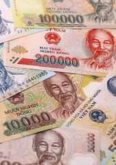 Fototapeta premium Vietnamese dong money bills pile on table. Vietnam banknotes of VND currency close up.