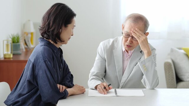 ノートに記入する高齢者の男性