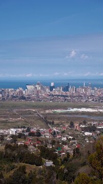 Expansive aerial panorama of batumi, georgia, featuring the modern city skyline and skyscrapers along the black sea coast with a view of surrounding landscape, mountains and urban area vertical video