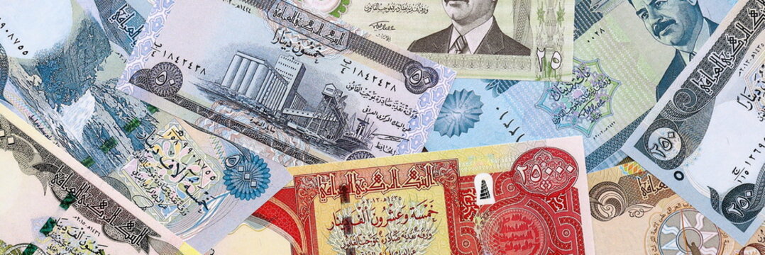 Iraqi dinar money bills pile on table. Iraq banknotes of IQD currency close up.