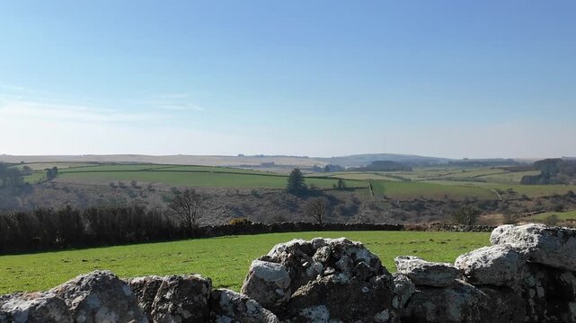Dartmoor Devon England. 27.03.2026. Video. Expansive view of patchwork fields and ancient stone boundaries stretching across  dartmoor in a gentle rural landscape on a bright day