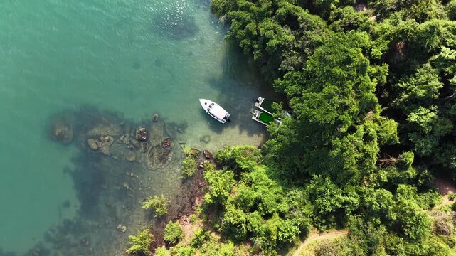 Single Boat Near the Forested Coastline of an Island