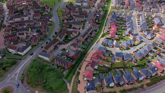 Aerial view of a modern residential housing estate with brick houses and winding streets in Ely, England, United Kingdom.