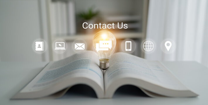 An open book showcases a glowing light bulb, representing ideas and communication. Contact icons above enhance the modern workspace setup and inspire connection. Gantry