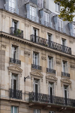 Classic Haussmannian Apartment Building Facade with Iron Balconies and Mansard Roof, Paris France
