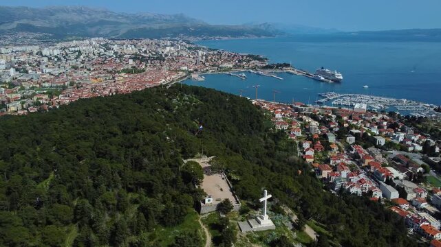 Aerial view of the white cross on Marjan Hill overlooking the historic city center and harbor in Split, Split-Dalmatia County, Croatia.