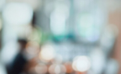 Fototapeta premium A blurred image depicting a modern workspace with people collaborating. The abstract representation highlights creativity and teamwork in a professional setting.