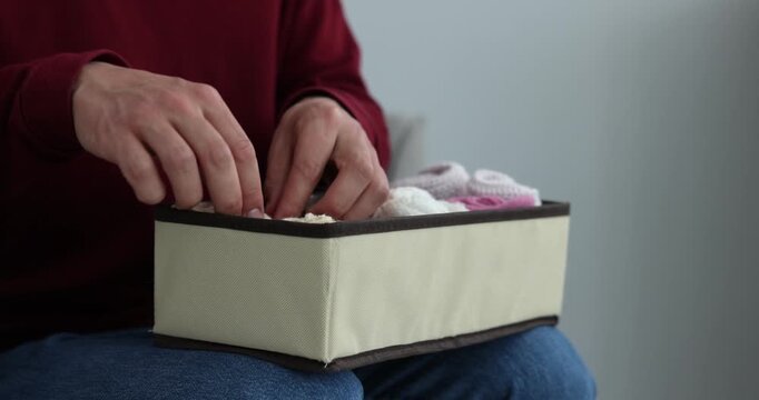 Man putting socks into organizer at home, closeup