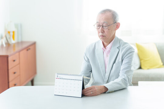 カレンダーを眺める高齢者の男性
