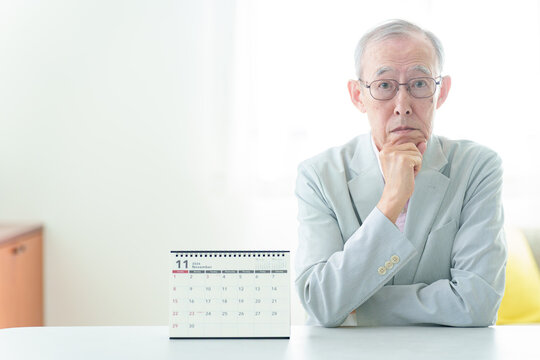 カレンダーを眺める高齢者の男性