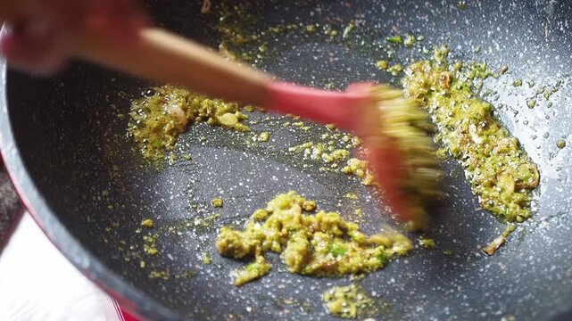 Cooking green curry paste in a wok, stir-frying, food preparation, Asian cuisine, close-up shot