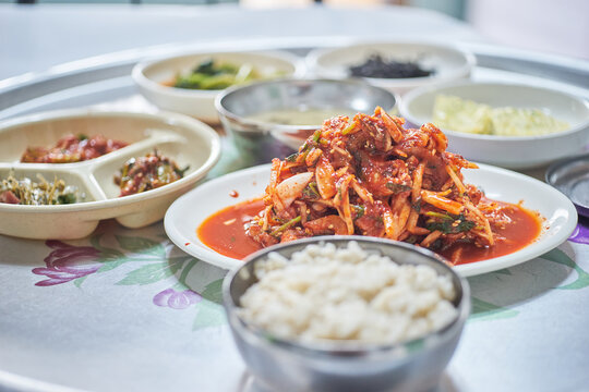 Unjeori muchim baekban is a traditional Korean meal featuring a spicy, tangy mudskipper salad served with warm rice and side dishes. Tossed in a vibrant red chili sauce, it offers a chewy delight.