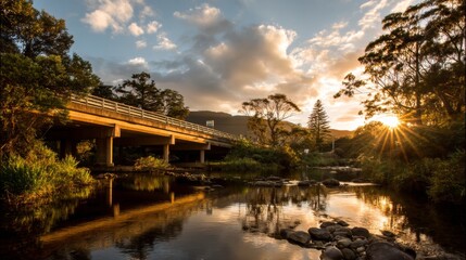 Fototapeta premium Serene Sunset Over Tranquil River with Bridge and Reflection Surrounded by Lush Greenery and Towering Trees in the Warm Golden Light of Dusk