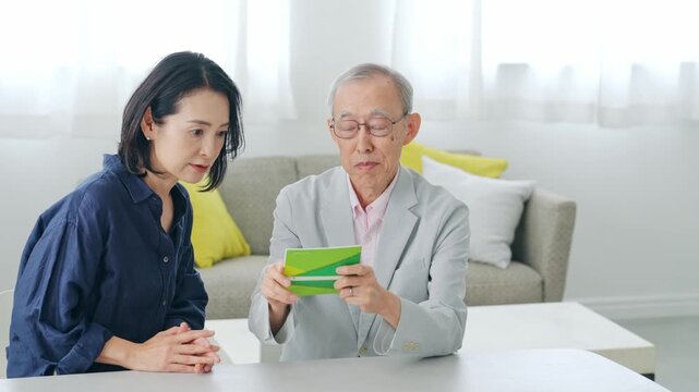 通帳を見ながら相談する女性とシニア男性