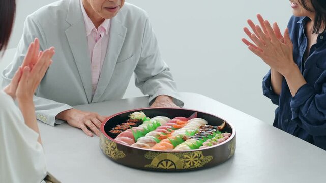 笑顔で寿司を食べる家族