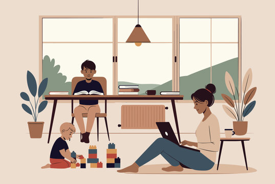 Mother works on her laptop while her older son reads a book at the table and her toddler plays with colorful building blocks on the floor.