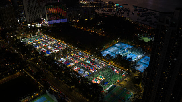 Hong Kong - 14 February 2026: Aerial view of the illuminated Lunar New Year Fair at Victoria Park with crowds of people, market stalls, and tennis courts at night.