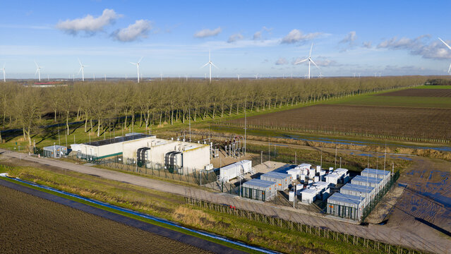 Zeewolde, Netherlands - 14 January 2026: Aerial view of an electrical substation and battery storage facility surrounded by agricultural fields and wind turbines.