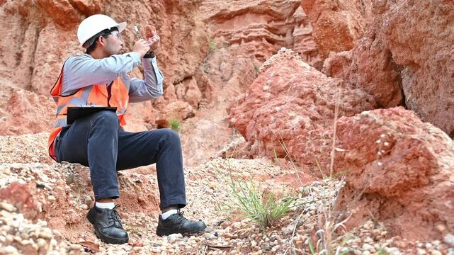 A specialist geologist is analyzing soil samples from inside a natural sinkhole for further study.