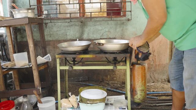 Filipino Vendor Preparing Portable Stove by Pumping Fuel Tank