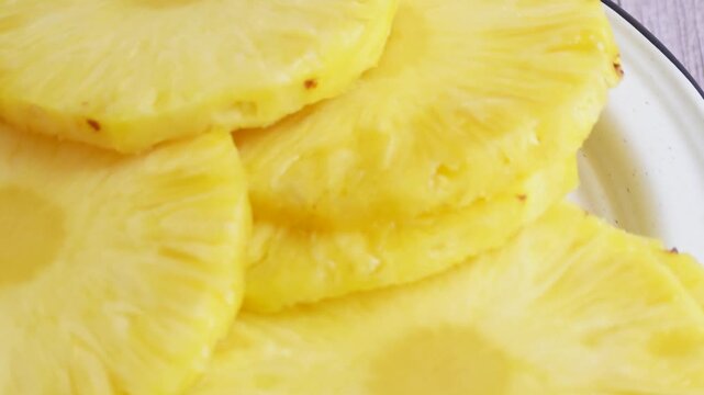 The fresh pineapple slices show a vibrant yellow flesh. Perfect for food blogs.