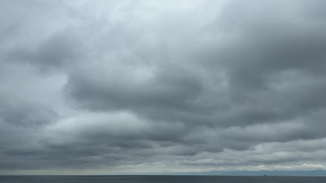 静かな海と連なる雲が描く曇天の風景