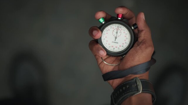 Close Up Referee Hand Holding Stopwatch During Match