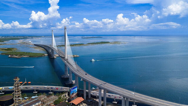 Cebu City, Philippines - 12 June 2026: Aerial view of the Cebu-Cordova Link Expressway bridge spanning across the Mactan Channel under a blue sky with white clouds.