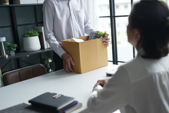 Business man sending resignation letter and packing Stuff Resign Depress or carrying business cardboard box Change of job or fired from company resign.