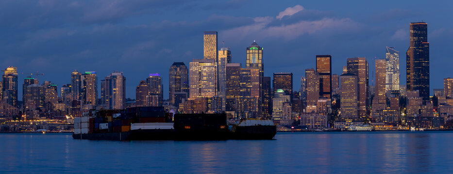 Seattle city skyline at night with cargo barge