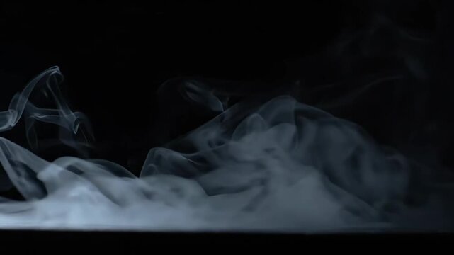 Ethereal and mysterious swirling smoke dances against dark background, creating captivating movement and texture that evokes calm and intrigue
