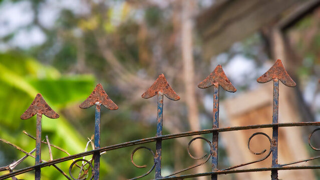 Close-up photo of rusty iron fence with arrow tips and aged texture. Perfect for industrial, security, and design themes.