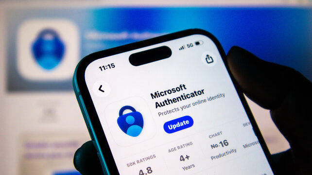 Closeup of a hand holding a smartphone displaying the microsoft authenticator app update screen on an app store