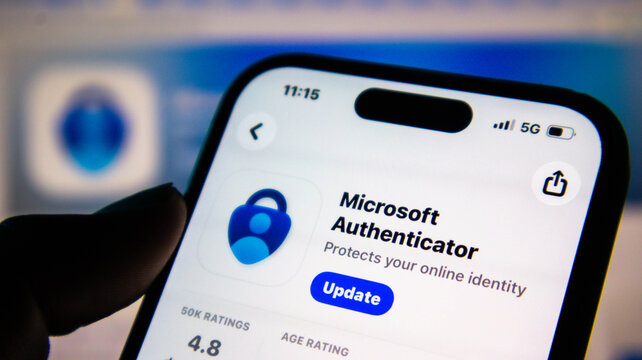 Hand holding smartphone showing microsoft authenticator app download page in app store with update button