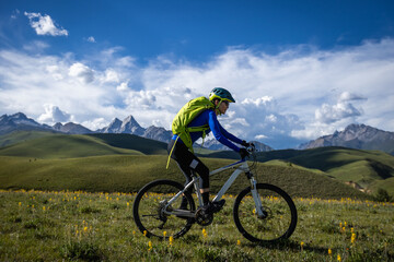 Fototapeta premium Mountain biking on flowering grassland mountains