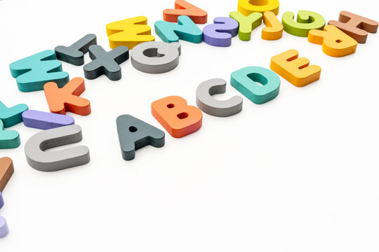 High Angle Studio Shot of Colorful Wooden Alphabet Letters Arranged on White Background