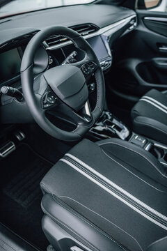 Modern car interior with focus on steering wheel and upholstered seats