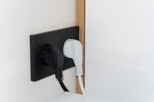 Black Sockets in the wall, wires in the socket on the kitchen wall, overloaded wall sockets, home fire safety concept. High quality